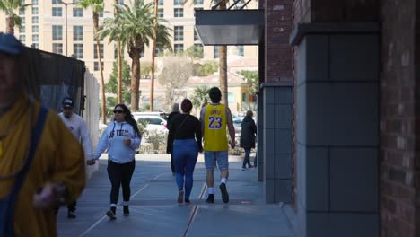 Tourists-walk-on-sidewalk-in-downtown-Las-Vegas,-lifestyle-street-scene