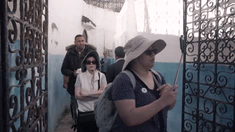 Grupo-De-Turistas-Caminando-Por-Una-Pequeña-Calle-Dentro-De-La-Antigua-Medina-De-Chefchaouen,-Marruecos