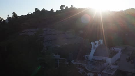 Wide-panning-aerial-shot-of-the-Hollywood-Bowl-with-lens-flare-during-sunset-in-Los-Angeles,-California