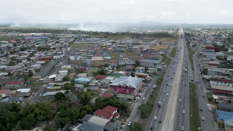 Autopista-Solomon-Hochoy-Chagauanas-Trinidad-Y-Tabago-Con-Incendios-Forestales-En-El-Horizonte-Drone-Aéreo-Movimiento-De-Izquierda-A-Derecha