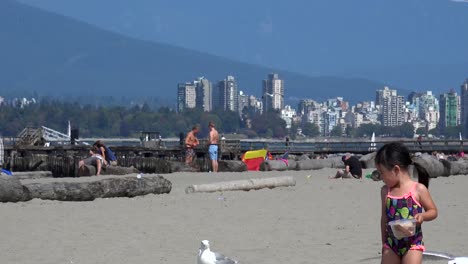 Una-Niña-Divertida-Alimenta-A-Las-Gaviotas-En-La-Playa.