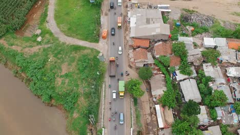 Aerial-view-drone-footage-overhead-shot-above-the-Citarum-bridge-over-the-Citarum-river-in-Bandung,-Indonesia,-with-traffic,-cars-and-trucks,-crossing-in-morning-light