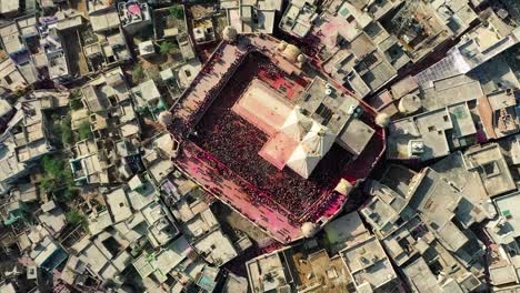 Vista-Aérea-De-Un-Dron-Con-Una-Cámara-Sobre-El-Templo.-Se-Ve-Un-Gran-Templo-Y-Mucha-Gente-Se-Está-Llenando-De-Polvo-Y-El-Dron-Sobrevuela-El-Templo.