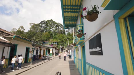 Vibrant-blue-yellow-trimmed-building-in-streets-of-Salento-Colombia-up-against-jungle-forest