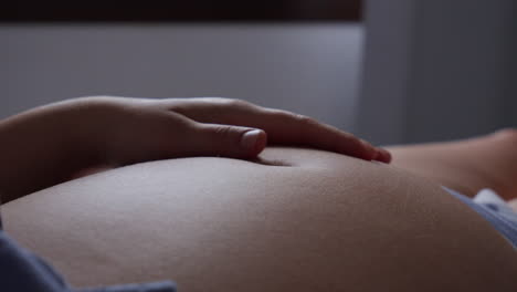 Close-up-of-a-pregnant-woman's-belly-with-a-gentle-hand-touch