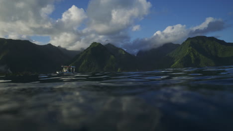 En-El-Agua,-Vista-De-Barcos-De-Apoyo-Para-Surfistas-Y-Montañas-Del-Valle-De-Tahití-En-Teahupoo.