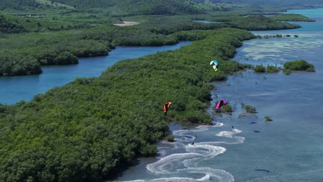 Kiteboarders-Navigating-Mangroves,-Tropical-Kitesurfing-Vacation,-Paradise,-Epic-Landscape,-Drone-Follow-Shot,-Wide-Angle