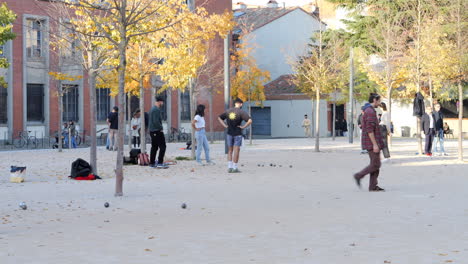 Jóvenes-En-Un-Parque-Público-Jugando-A-La-Petanca-En-El-Suelo-En-Toulouse,-Francia