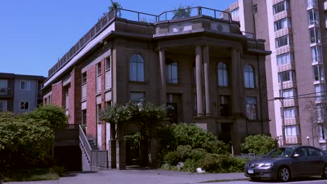 Old-historic-brick-building-with-people-and-cars-passing