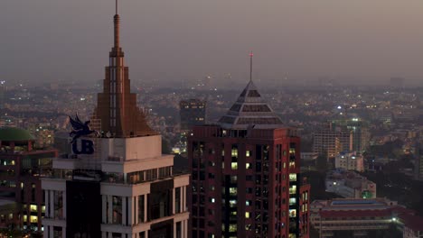 Aerial-View-Of-Top-Half-Of-UB-Tower-In-Business-district-in-Bengaluru-with-orange-sunset-skies-in-background