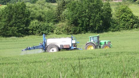 Ein-Grüner-Traktor-Zieht-Einen-Blauen-Tank-Hinter-Sich-Her-Und-Düngt-Das-Feld-Im-Sauerland