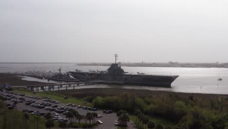 Aerial-wide-rising-shot-of-the-historic-USS-Yorktown-CV-10-aircraft-carrier-at-Patriot's-Point-on-a-hazy-day-in-Mount-Pleasant,-South-Carolina