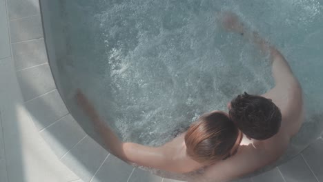 Top-shot-of-a-couple-in-a-spa-jacuzzi,-the-water-is-bubbling