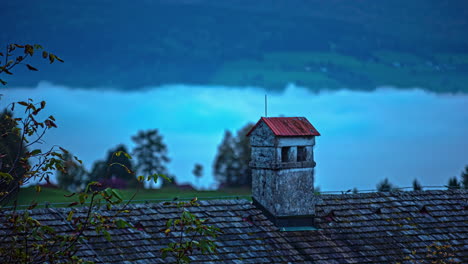 Casa-Solitaria-Antigua-Chimenea-Europea-En-El-Valle-De-Los-Alpes-Austríacos-Paisaje-De-Lapso-De-Tiempo-Húmedo-Ladrillos-De-Piedra-Casa-Con-Techo-De-Tejas-Rojas