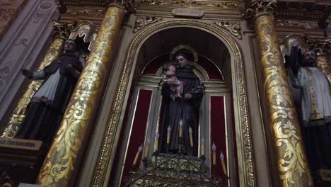 Statue-of-christian-saints-holding-a-baby-and-praying-inside-basilica-church-golden-eclectic-architecture-of-buenos-aires-argentina