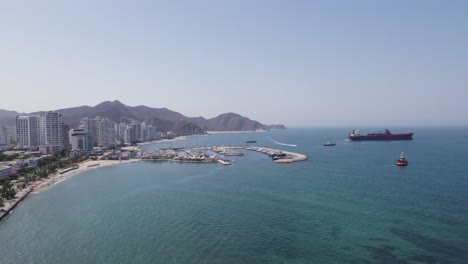 Coastline-and-skyline-of-Santa-Marta,-Colombia,-aerial-sideways-sunny-day