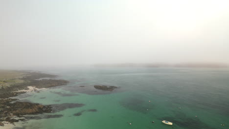 Upward-Aerial-View-of-Beach-With-Boat-in-Foggy-Sky