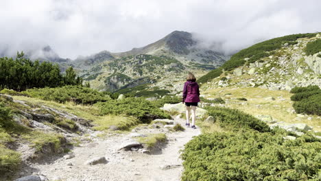 A-girl-walking-on-a-pathway-with-junipers-in-the-Retezat-Mountains-in-Romania