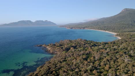 Drone-shot-of-landscape-of-Freycinet-National-Park-with-a-dense-forest-in-foreground-in-Tasmania,-Australia