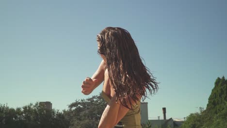 View-of-a-young-woman-in-a-swimsuit-brushing-her-wet-hair-by-hand