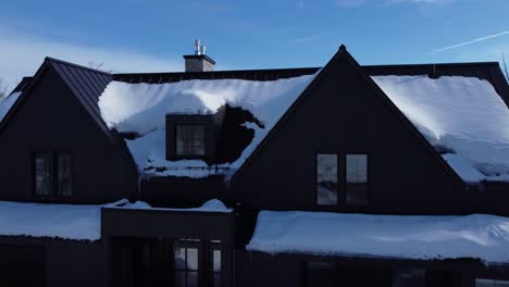 Aerial-shot-rising-over-a-snow-covered-Luxury-Chalet