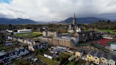 Un-Dron-Cinematográfico-En-Ascenso-Disparó-Killarney,-Irlanda,-La-Catedral-De-Santa-María-Con-Las-Montañas-Del-Parque-Nacional-Al-Fondo