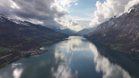 Aerial-view-of-a-serene-lake-reflecting-clouds-between-mountain-ranges