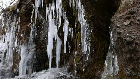 Icicles-on-rock-face-near-river.-Iceland