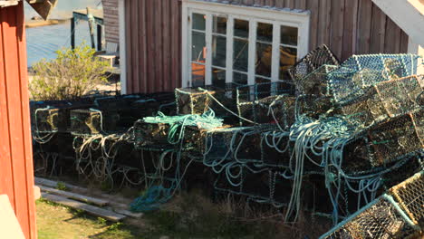 Lobster-Cages-Clustered-Outside-Traditional-Red-Wooden-Fisherman's-Hut,,-Sweden