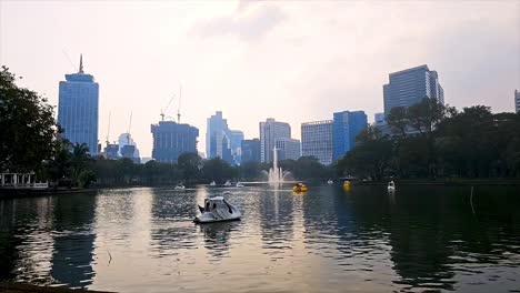 Los-Lugareños-Y-Los-Turistas-Se-Relajan-Y-Reman-En-Algunos-Elegantes-Botes-De-Remos-A-última-Hora-De-La-Tarde-En-Medio-Del-Parque-Lumpini,-En-Bangkok,-Tailandia