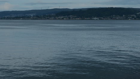 Slow-motion-water-in-front-of-distant-seaside-town