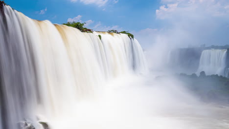 Timelapse-of-a-big-Waterfalls-of-Iguazu-around-a-big-green-area-and-a-river,-in-a-sunny-day,-Foz-do-Iguacu,-Parana,-Brazil