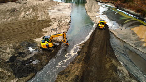 Luftaufnahme-Eines-Bulldozers,-Der-Erde-Vorschiebt,-Um-Den-Letzten-Flusslauf-Abzudecken-Und-Die-Landentwicklung-Zu-Fördern