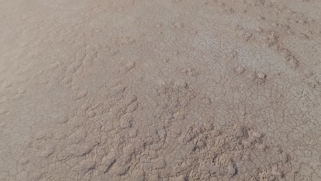 Drone-clip-showing-wide-expanse-of-dry-and-cracked-ground-in-outback-desert-in-WA,-Australia