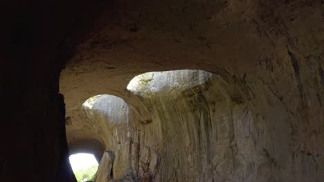 Schwenken-Von-Links-Nach-Rechts-Zeigt-Das-Ikonische-Loch,-Das-Gemeinhin-Als-Gottes-Augen-Bezeichnet-Wird,-In-Der-Prohodna-Höhle-In-Karlukovo-In-Bulgarien