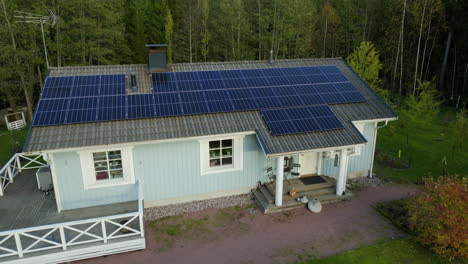 Dron-Dando-Vueltas-Alrededor-Del-Exterior-De-Una-Casa-Solar-Ecológica,-En-Una-Soleada-Tarde-De-Otoño