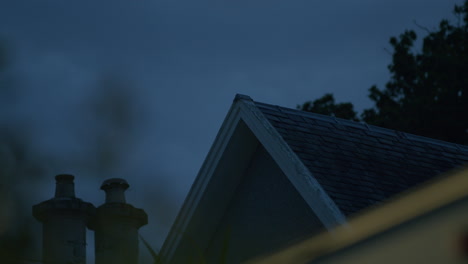 Roof-of-house-and-two-chimneys-in-low-evening-light