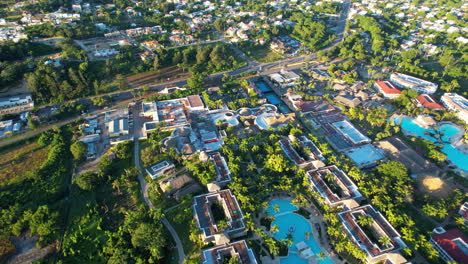 Inclinación-Aérea-De-Un-Hotel-Resort-De-Lujo-Con-Piscina-Privada-Y-Tráfico-En-La-Autopista