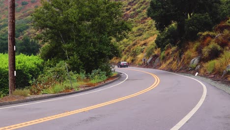 Dos-Autos-Aceleran-Por-Caminos-De-Montaña,-Siguiendo-Una-Línea-Continua-A-Través-De-Paisajes-Escénicos.