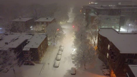 Una-Vista-Aérea-De-Las-Calles-Del-Centro-Cubiertas-Por-Un-Manto-De-Nieve-Por-La-Noche.