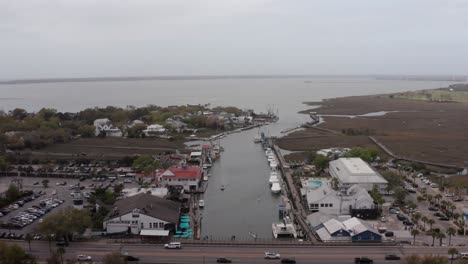 Aerial-wide-reverse-pullback-shot-of-Shem-Creek-on-a-hazy-day-in-Mount-Pleasant,-South-Carolina