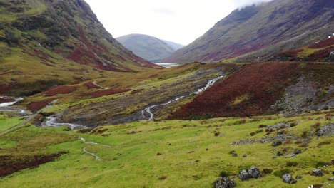 Luftaufnahme-Der-Dramatischen-Glencoe-Landschaft-In-Schottland-Mit-Dem-Fluss-Coe,-Der-In-Der-Mitte-Fließt