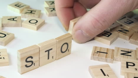 Word-STOCK-formed-from-Scrabble-tile-letters-on-edge-on-white-table