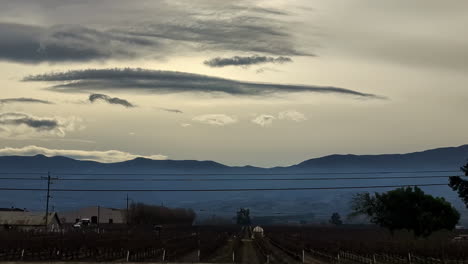 Vista-Del-Coche-Del-Asiento-De-La-Ventana-Del-Campo-De-EE.UU.-En-Los-Campos-De-California-Al-Anochecer-árboles-Del-Horizonte-Y-El-Tráfico-En-La-Carretera-Suburbana