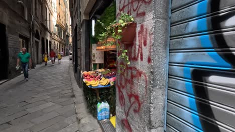 Zeitlupenclip-Beim-Spaziergang-Durch-Eine-Ruhige-Straße-Mit-Straßenkunst-Im-Graffiti-Stil-Und-Frischem-Obst-In-Einem-Laden-Mit-Offener-Front