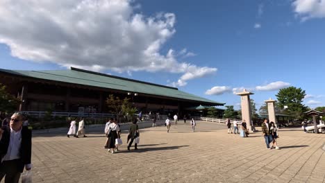 Los-Visitantes-Pasean-Por-La-Zona-De-La-Plaza-Frente-Al-Edificio-De-La-Terminal-De-Ferry-De-Miyajima,-Que-Representa-La-Esencia-Del-Viaje-Y-La-Exploración-Cultural.