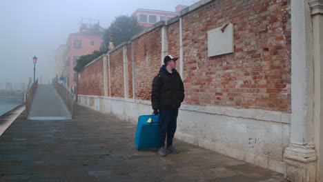 Solitary-traveler-in-foggy-Venice,-Italy