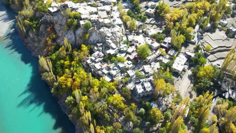 Aerial-Overhead-View-Of-Autumnal-Trees-In-Skardu-Village-Beside-Turquoise-Indus-River