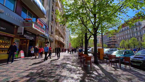 Busy-downtown-street-of-Prague-on-sunny-day,-waling-POV-in-slow-motion