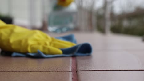 Woman-cleaning-tile-floors-outdoors,-spring-cleaning,-4k-footage,-tile-cleaning